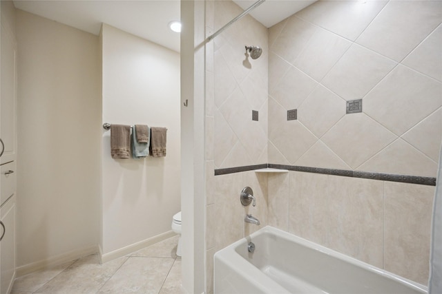 bathroom featuring tiled shower / bath, tile patterned floors, and toilet