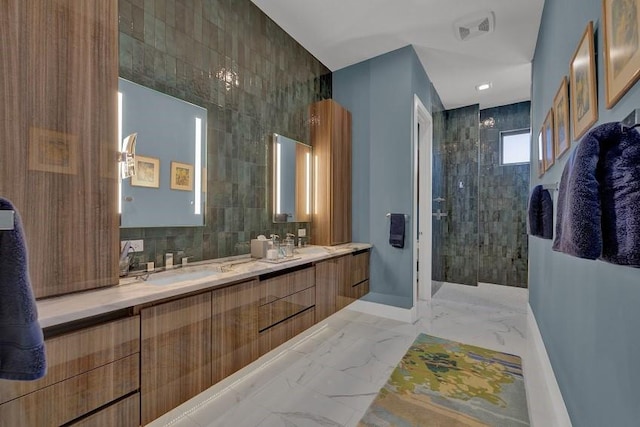 bathroom featuring tasteful backsplash, vanity, tile walls, and a tile shower