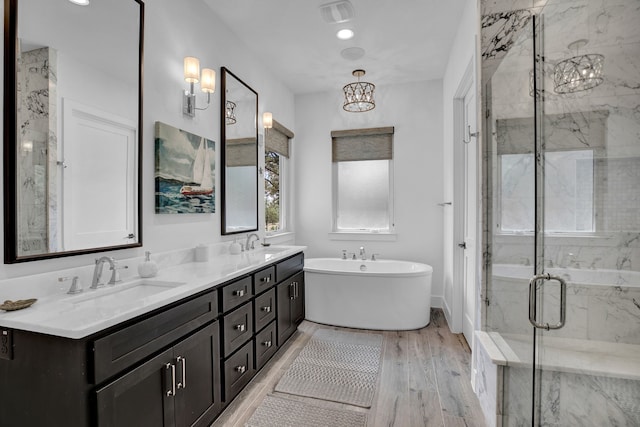 bathroom with independent shower and bath, vanity, and hardwood / wood-style flooring