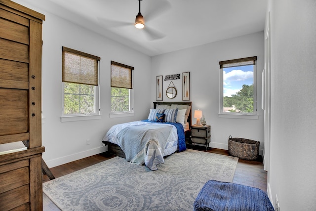 bedroom with multiple windows, wood-type flooring, and ceiling fan