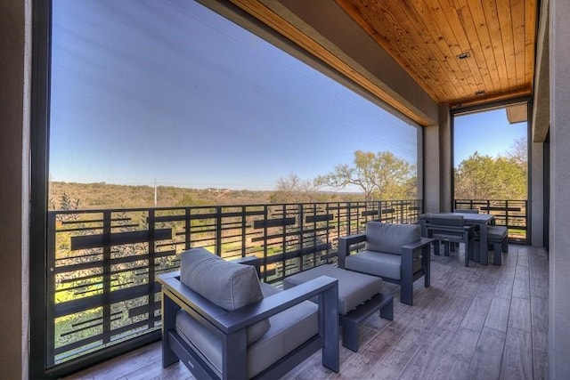 wooden deck featuring a rural view, outdoor lounge area, and a balcony