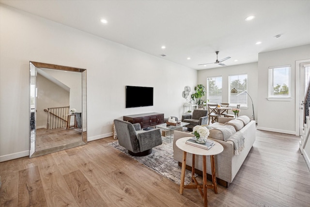 living room with ceiling fan and light hardwood / wood-style flooring