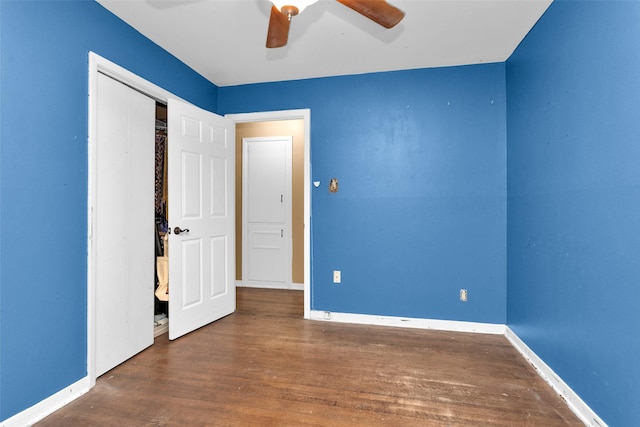 unfurnished bedroom with ceiling fan, dark hardwood / wood-style flooring, and a closet