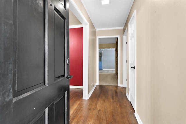 corridor with ornamental molding and dark wood-type flooring