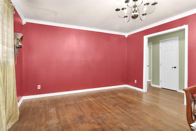 unfurnished room featuring crown molding, hardwood / wood-style floors, and a notable chandelier