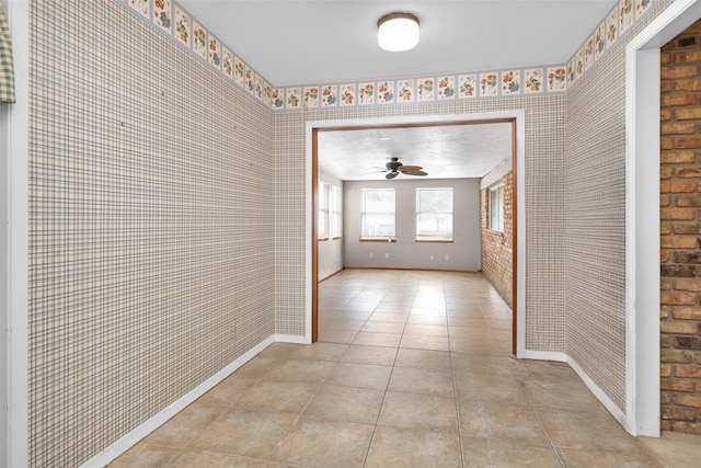 hall with brick wall and light tile patterned floors