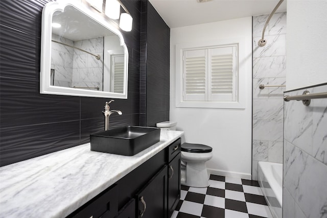 full bathroom with tiled shower / bath, vanity, and toilet