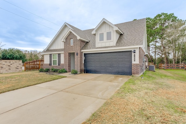 view of front of home with a garage, a front yard, and central air condition unit