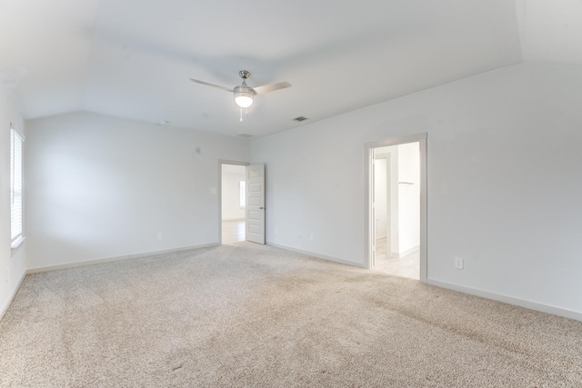 carpeted spare room with ceiling fan and vaulted ceiling