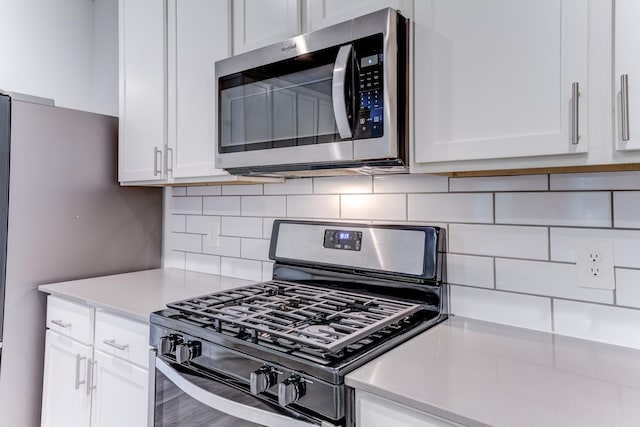 kitchen featuring white cabinetry, appliances with stainless steel finishes, and backsplash