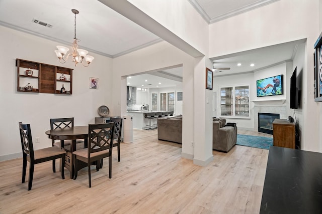 dining room featuring a notable chandelier, light hardwood / wood-style flooring, and ornamental molding