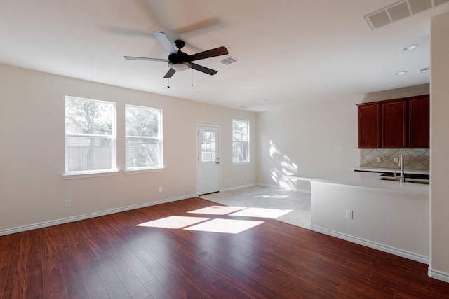 interior space featuring ceiling fan, wood-type flooring, and sink