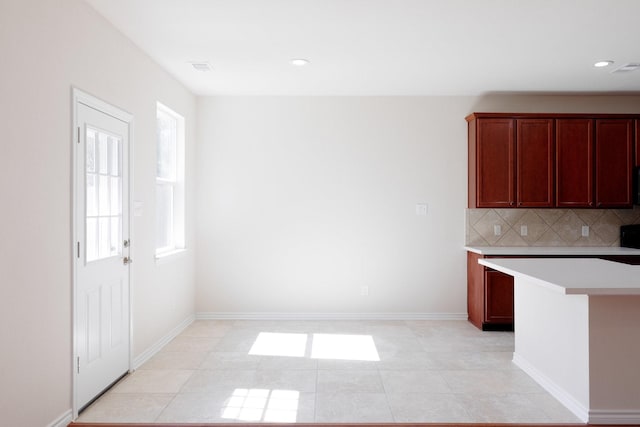 kitchen featuring light tile patterned floors, baseboards, recessed lighting, decorative backsplash, and light countertops