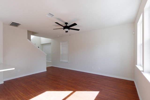 spare room featuring visible vents, baseboards, wood finished floors, and a ceiling fan