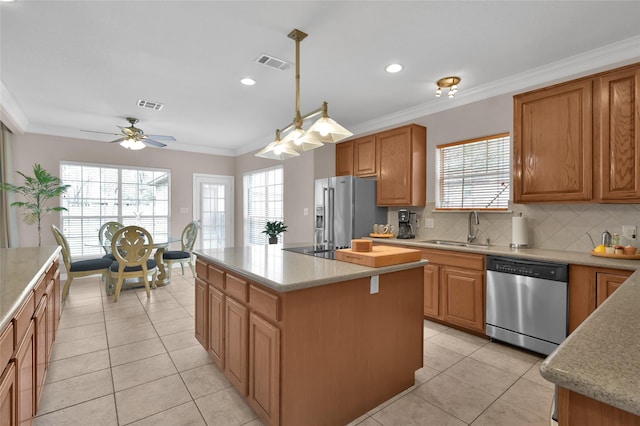 kitchen with a sink, a kitchen island, visible vents, light countertops, and appliances with stainless steel finishes