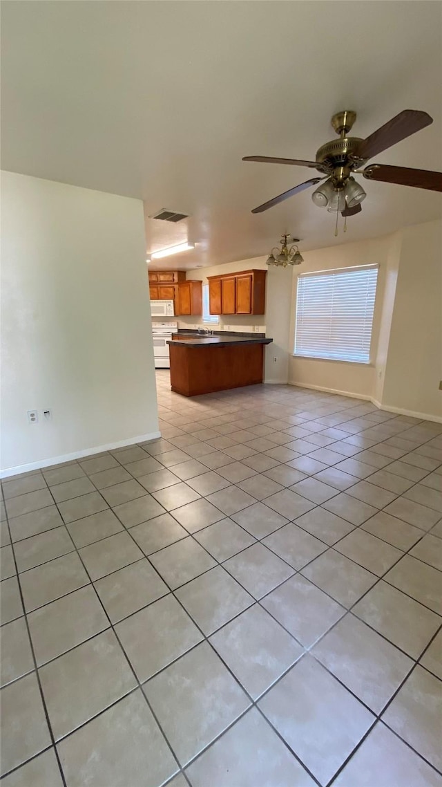 unfurnished living room featuring light tile patterned flooring, ceiling fan, and a wealth of natural light