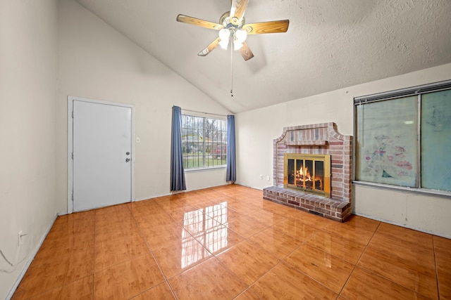 unfurnished living room featuring ceiling fan, tile patterned flooring, high vaulted ceiling, a textured ceiling, and a brick fireplace