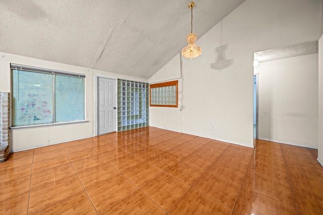 interior space featuring lofted ceiling, tile patterned flooring, and a textured ceiling