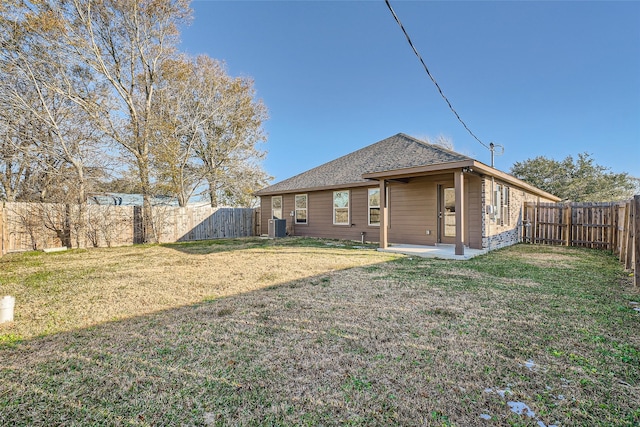 rear view of property with a yard, central AC, and a patio area