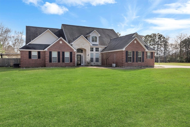 view of front facade featuring a front yard and central air condition unit