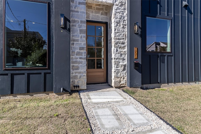 view of exterior entry featuring a lawn