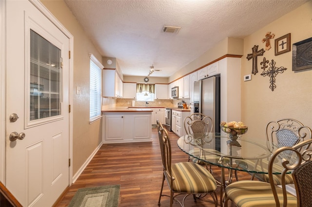 dining area with dark hardwood / wood-style flooring and a textured ceiling