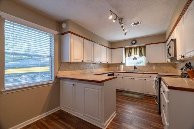 kitchen featuring white cabinetry, appliances with stainless steel finishes, and wooden counters