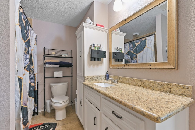 bathroom with vanity, toilet, tile patterned flooring, and a textured ceiling