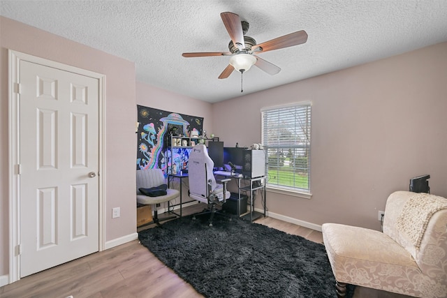 office featuring hardwood / wood-style floors, a textured ceiling, and ceiling fan