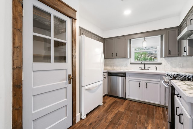 kitchen with dark hardwood / wood-style flooring, sink, gray cabinets, appliances with stainless steel finishes, and decorative backsplash