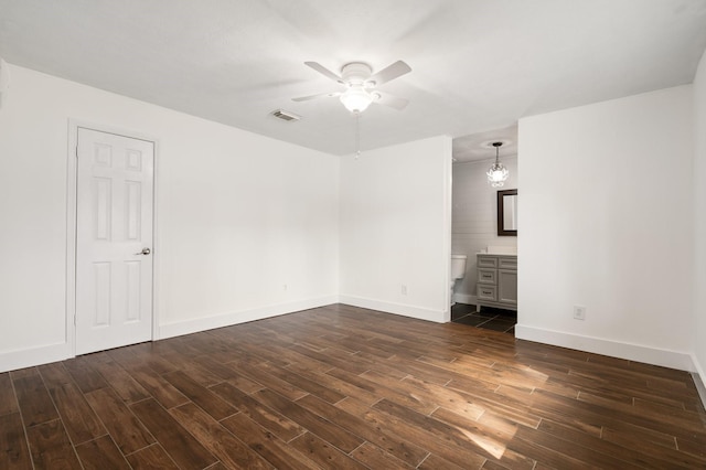 empty room with dark hardwood / wood-style flooring and ceiling fan