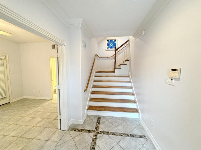 stairs featuring tile patterned flooring, crown molding, and baseboards