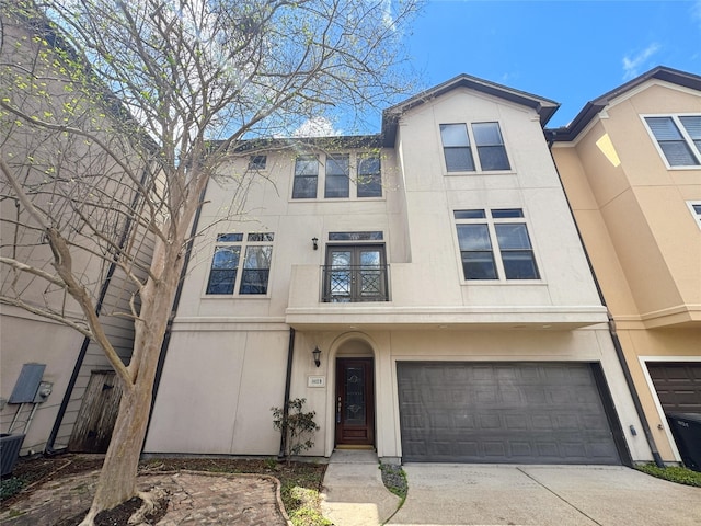 view of property featuring stucco siding, driveway, and a garage