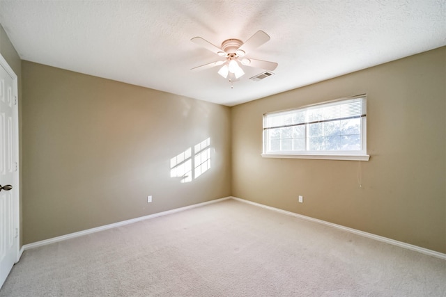 carpeted spare room with ceiling fan and a textured ceiling