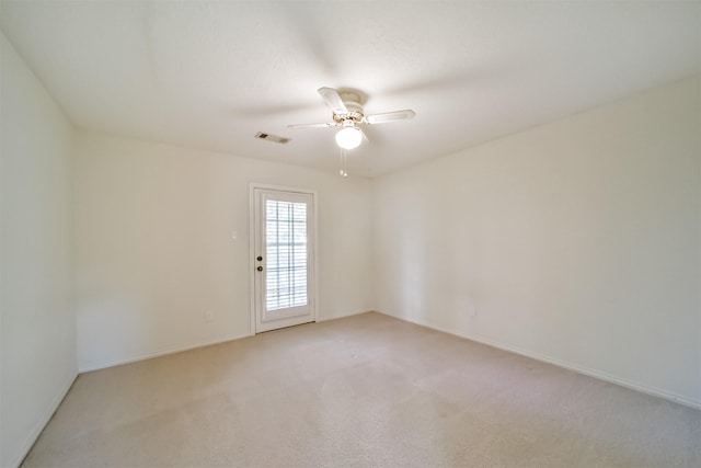 spare room featuring light carpet and ceiling fan