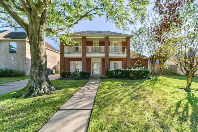 view of front of property featuring a balcony and a front yard