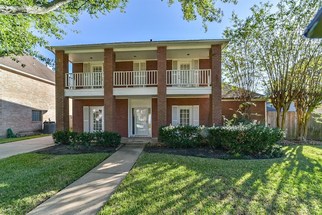 view of front of home with a balcony, central air condition unit, and a front lawn