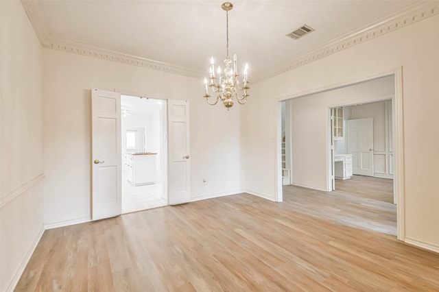 spare room featuring ornamental molding, a notable chandelier, and light hardwood / wood-style floors