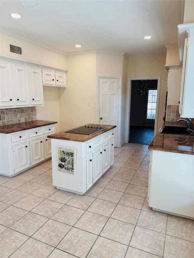 kitchen featuring light tile patterned flooring, sink, white cabinets, a center island, and black electric cooktop