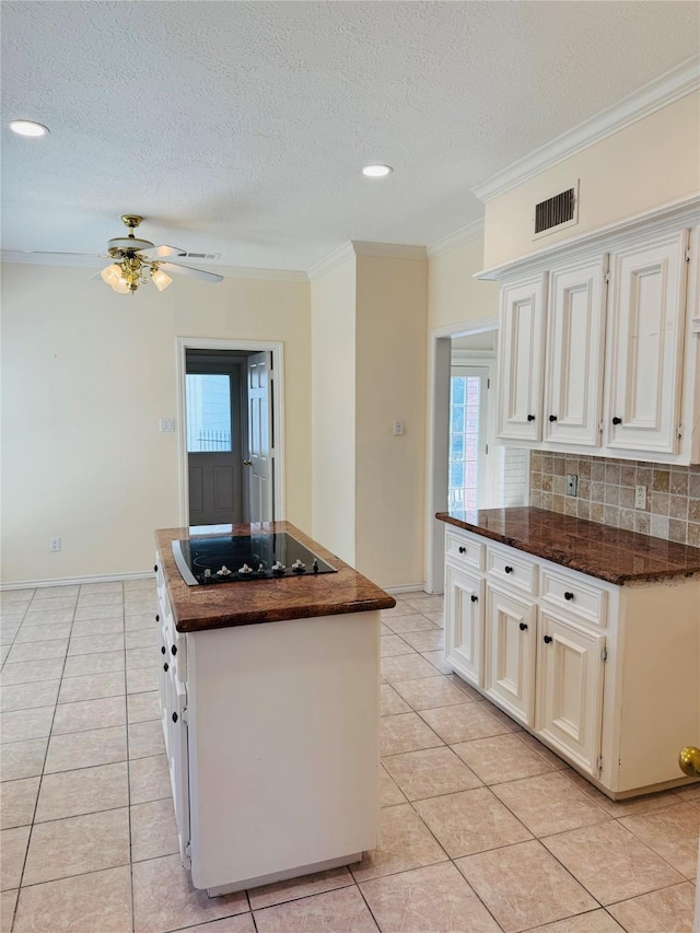 kitchen with black electric cooktop, white cabinetry, tasteful backsplash, and a kitchen island