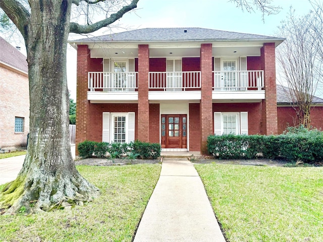 view of front of house featuring a front yard and a balcony