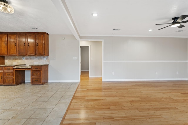 kitchen with light hardwood / wood-style flooring, ceiling fan, tasteful backsplash, built in desk, and ornamental molding