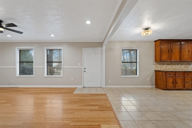 tiled entrance foyer featuring a textured ceiling, plenty of natural light, and ceiling fan