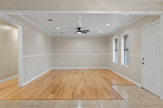 tiled empty room featuring ceiling fan and ornamental molding