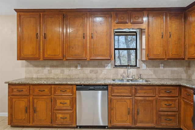 kitchen featuring tasteful backsplash, sink, light stone counters, and dishwasher