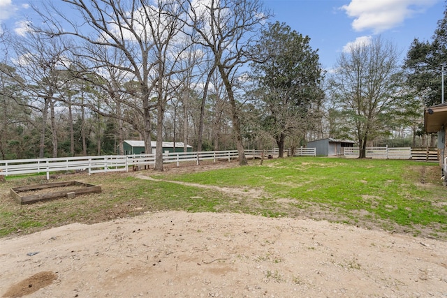 view of yard with an outdoor structure and a rural view