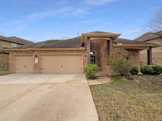 view of front of house with concrete driveway, brick siding, an attached garage, and roof with shingles