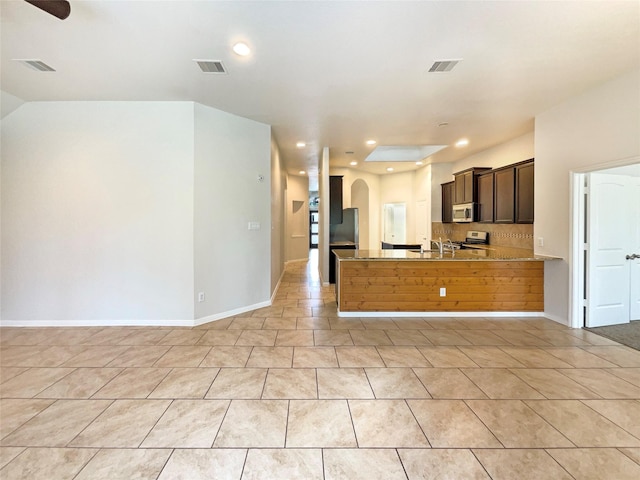 kitchen featuring a peninsula, tasteful backsplash, appliances with stainless steel finishes, and visible vents