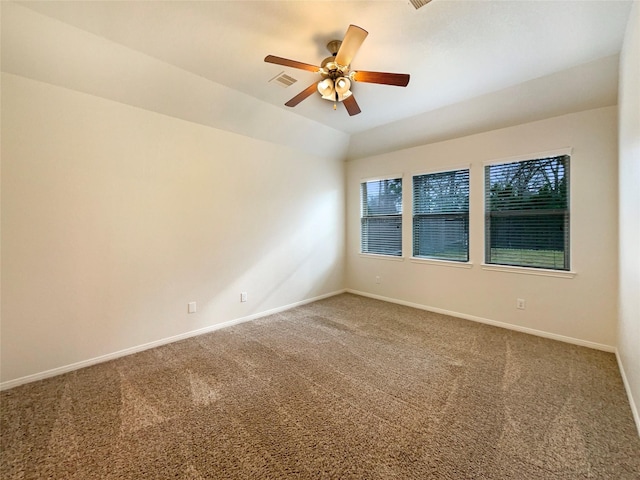 spare room with carpet floors, baseboards, visible vents, and lofted ceiling