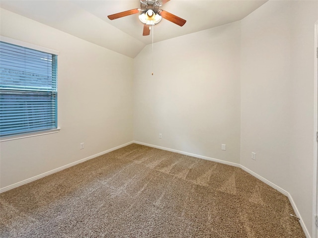 carpeted spare room with lofted ceiling, ceiling fan, and baseboards